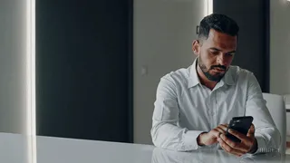 Empresario revisando desde su smartphone los comentarios en ReclameAQUI Brasil relacionados con su empresa.